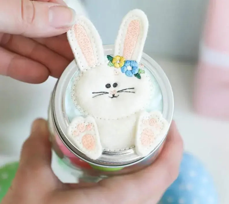 Person holding a small container with a decorative rabbit figure on top