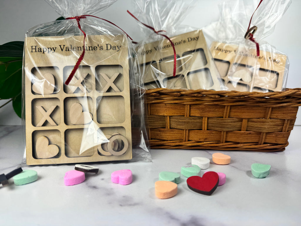 Wooden letter and heart stamps with cellophane-wrapped packaging and colorful heart-shaped candies on a marble surface. (Sewing Bee Studio)
