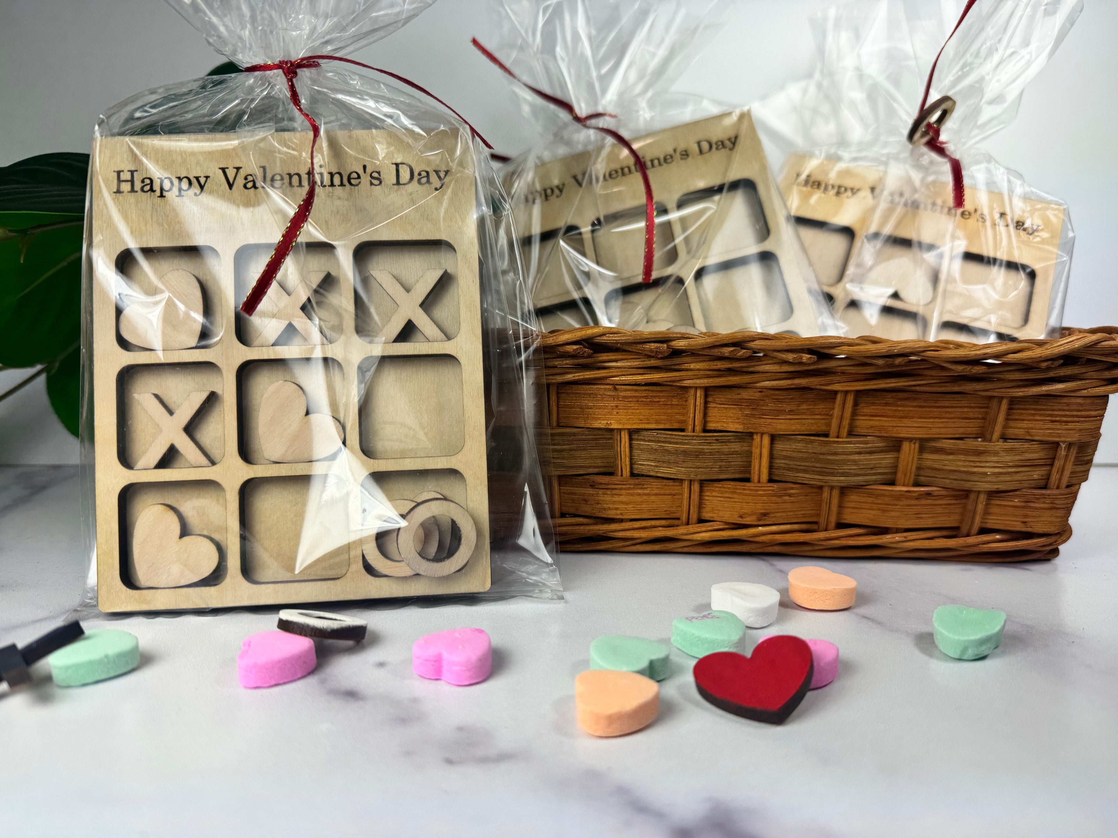 Wooden letter and heart stamps with cellophane-wrapped packaging and colorful heart-shaped candies on a marble surface. (Sewing Bee Studio)