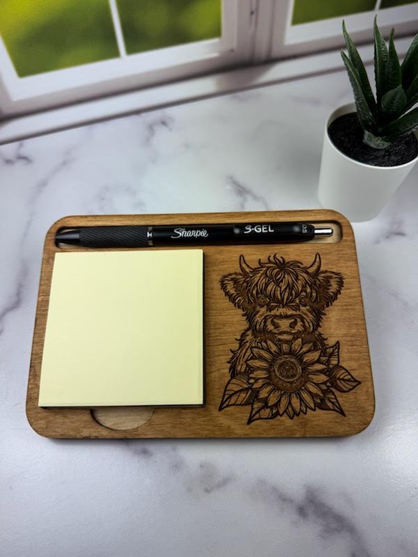 Wooden desk organizer with a pen, sticky notes, and a highland cow design on a marble surface. Sewing Bee & laser Studio.