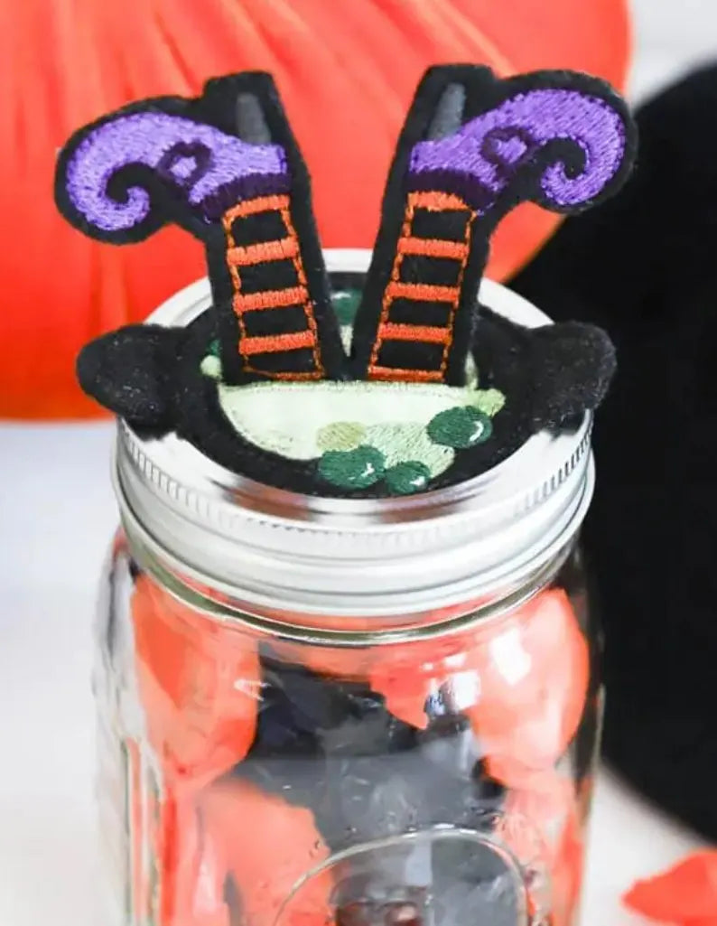 Mason jar with witch's legs decoration on a white background