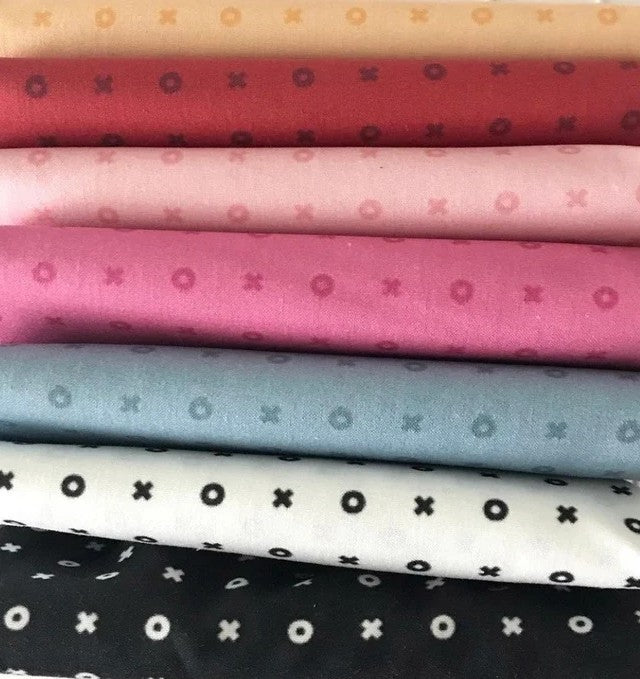 Stack of fabric fat-quarters with various patterns and colors. Sold by Sewing Bee Studio.