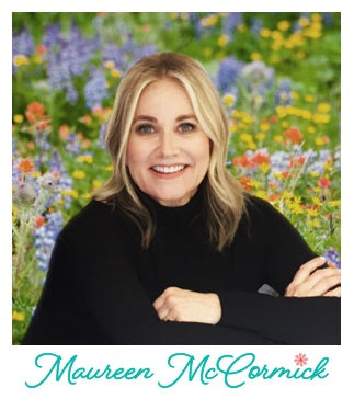 Fabric designer, Maureen McCormick in black sweater posing in a field of colorful flowers, promoting fabric collection, "Flower Power," bundle sold by Sewing Bee Studio.