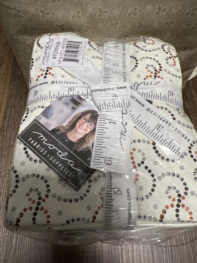 Packaged fabric with ruler design and MoLa label on a wooden surface